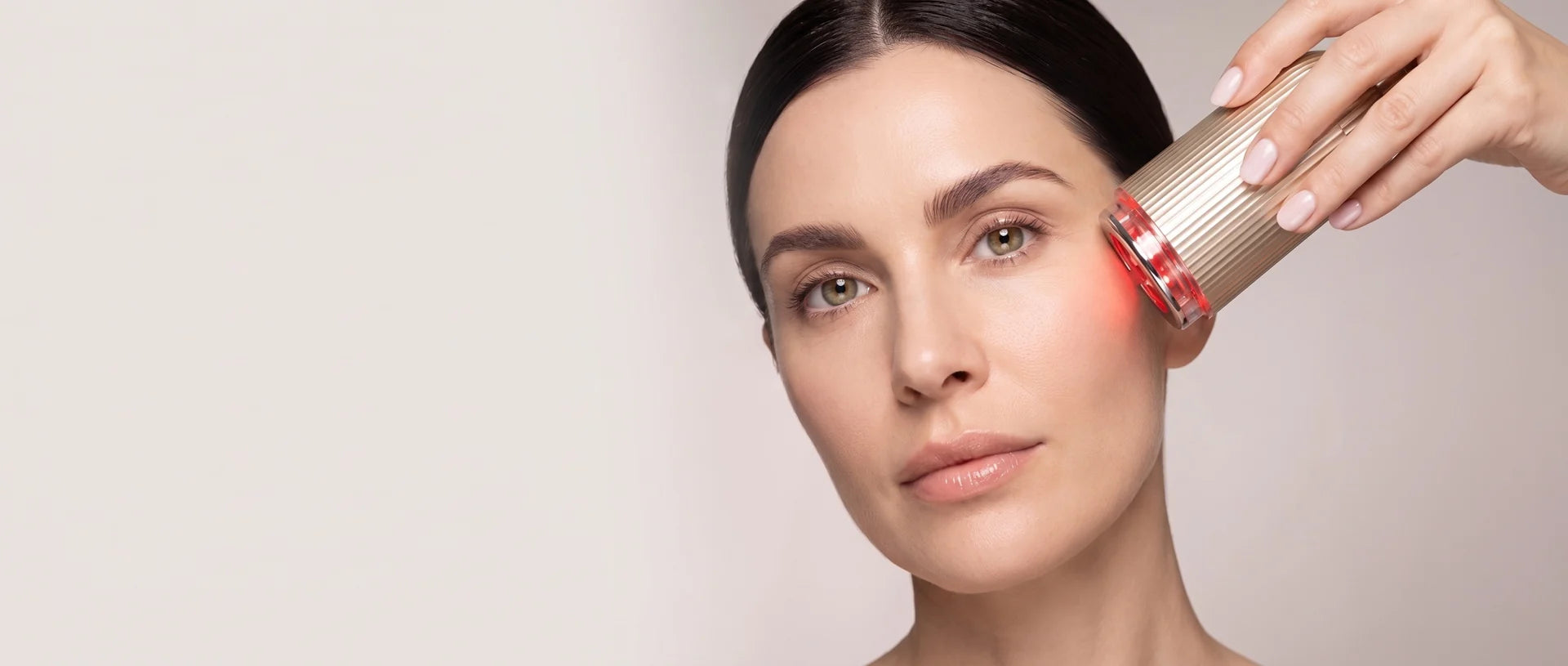 Woman using the champagne-gold FLOW+ on her cheek