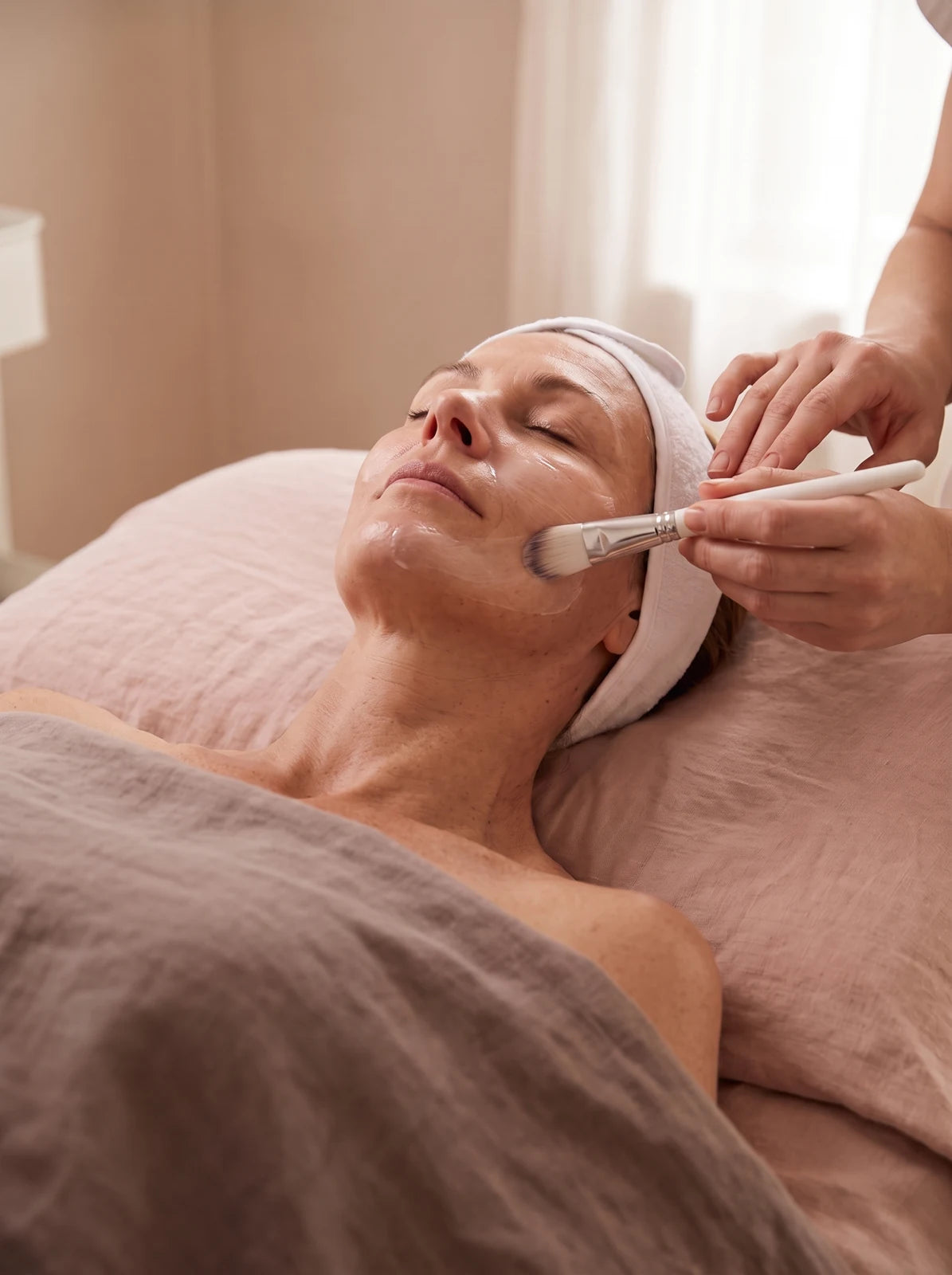 A professional applying skincare during a facial appointment